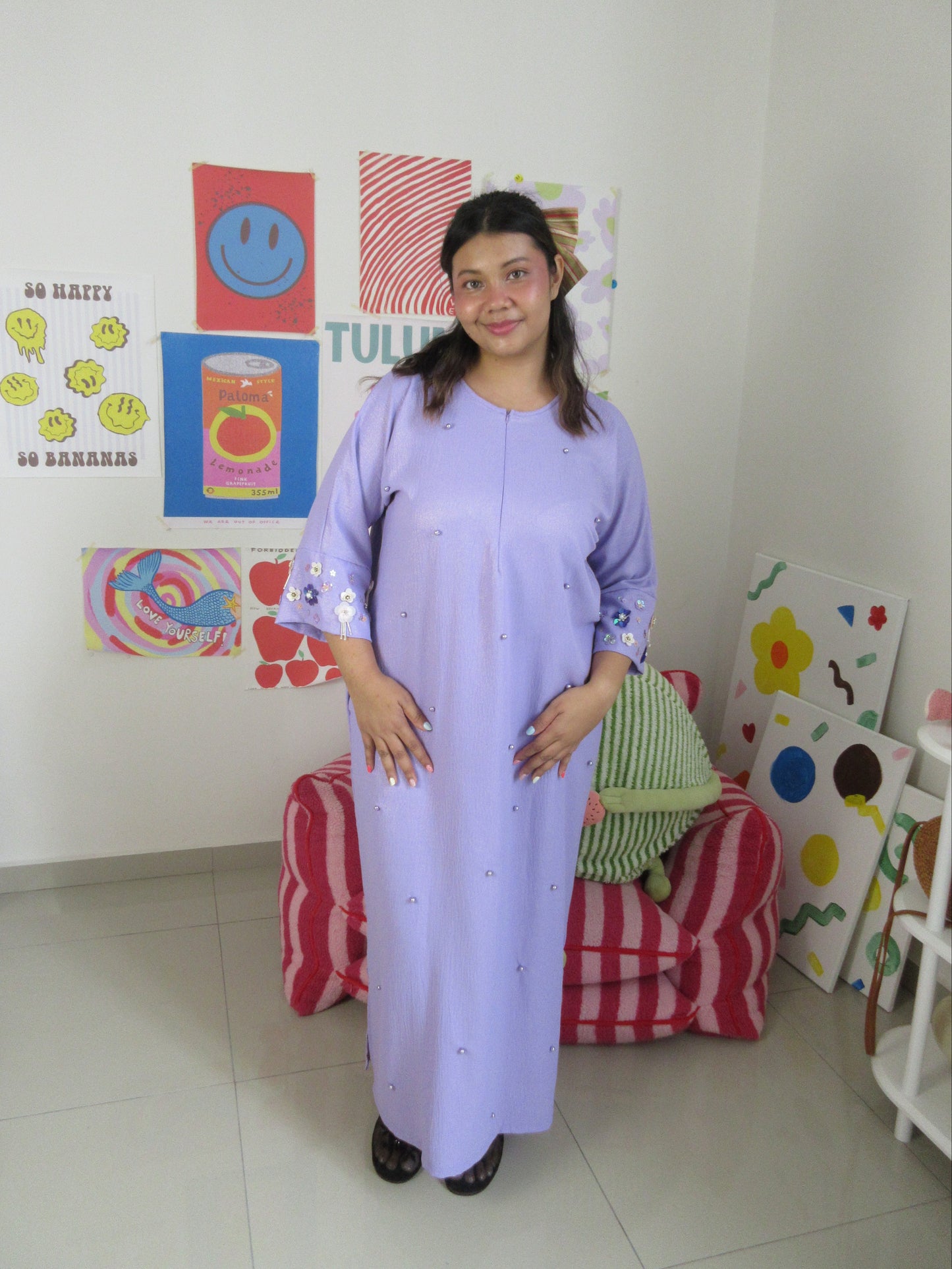Woman in a light purple dress standing with the most stunning Malaysia's designer dress