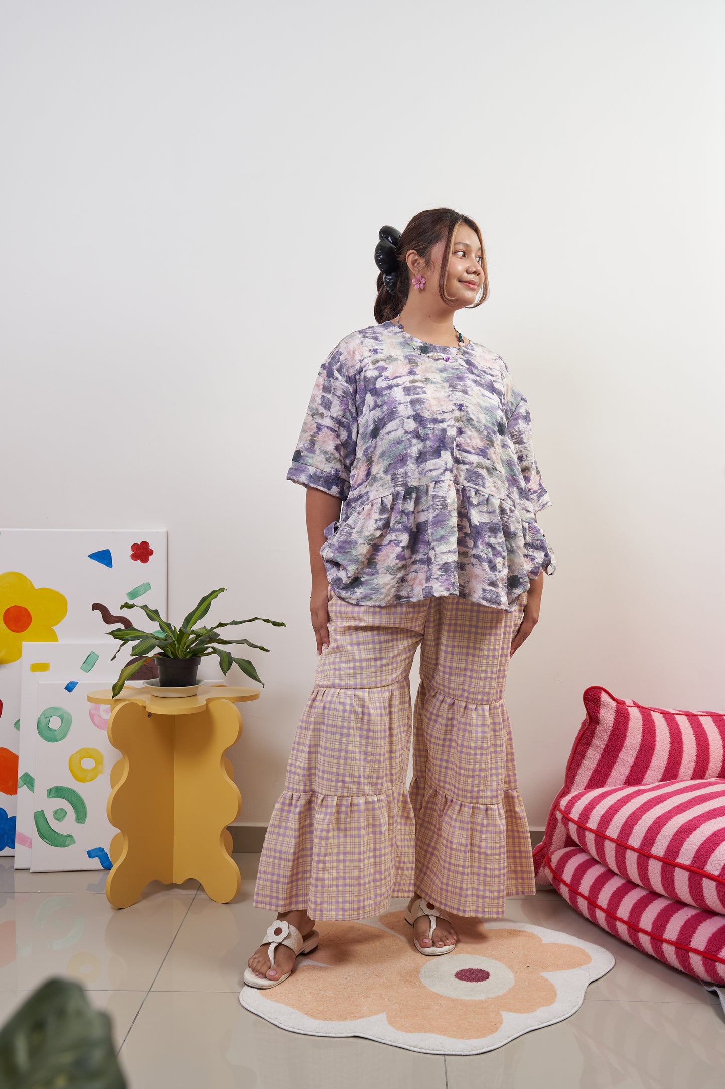 Full-body front view of Liliana Top in Wisteria with ribbon tied at side, paired with Flutter Tier Pants in Orchid Zest, highlighting peplum style and playful ruffled pants.