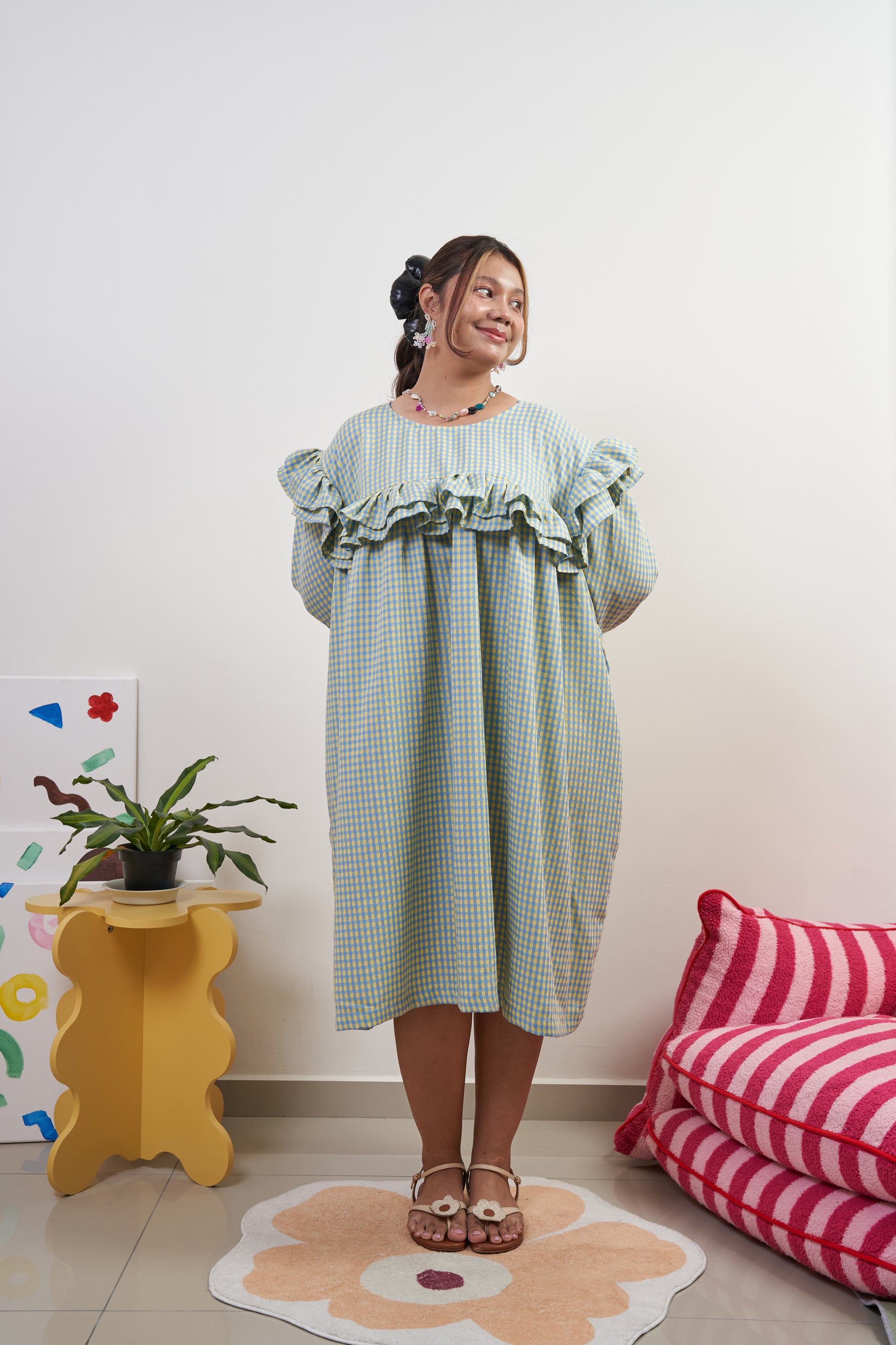 Front view of Rhea Dress in Felicia Daisy, yellow and blue gingham print, featuring a trapeze silhouette with playful ruffles and two side pockets