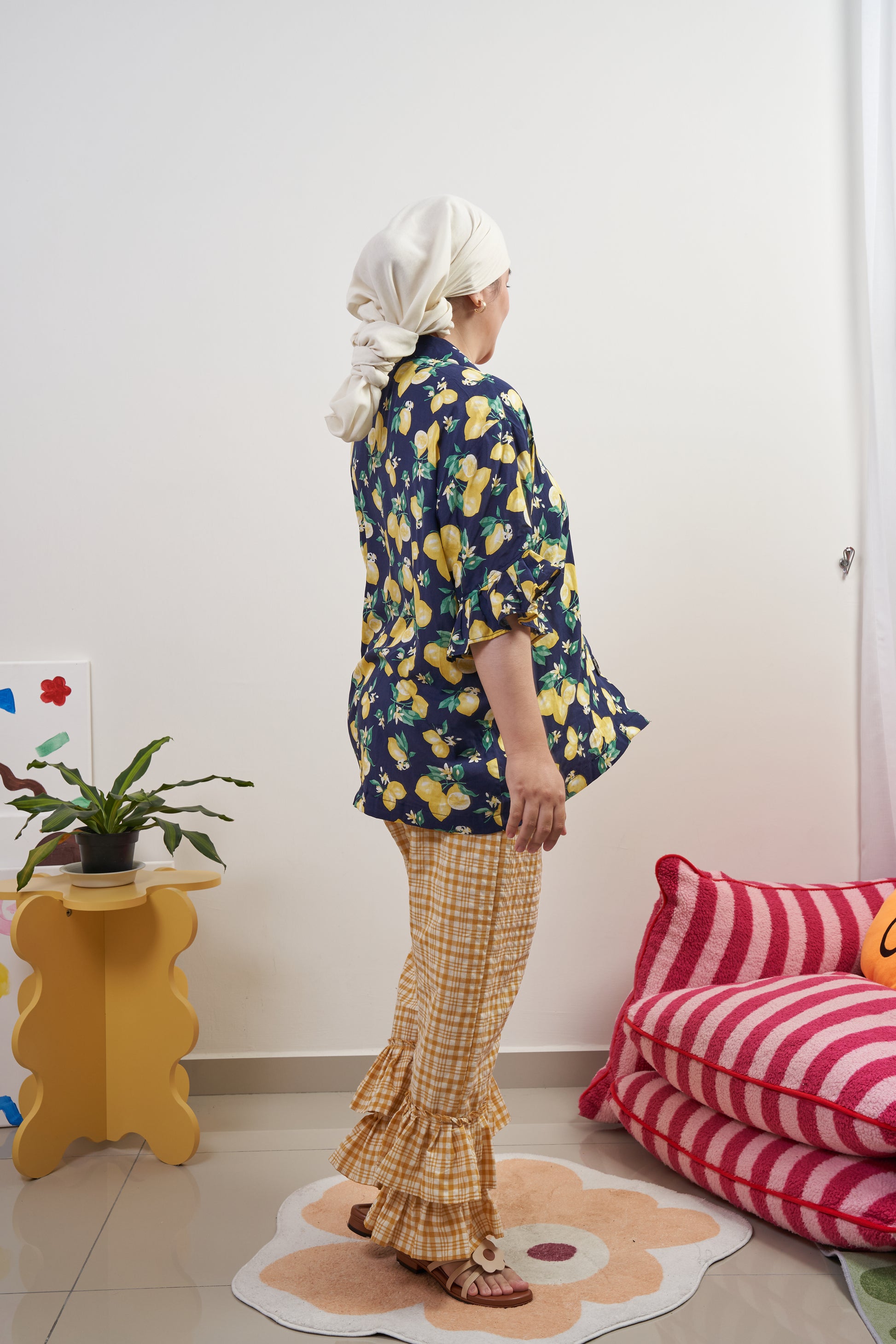 Side profile of Buttoned Belle Blouse in Lemon Dream, twirling to show breezy movement, paired with Flutter Flair Pants in Lemonade for a complete set