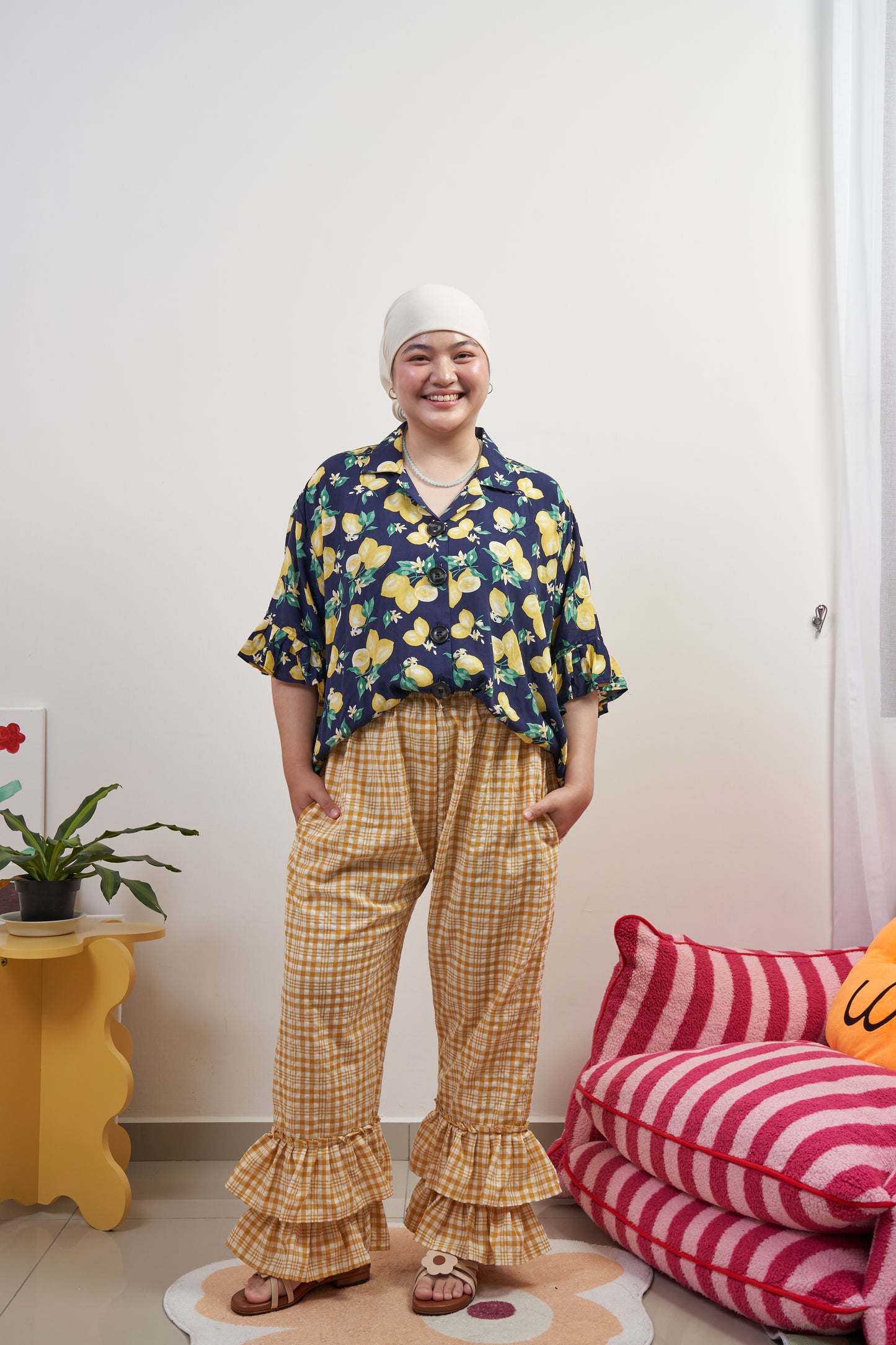 Full frontal view of Flutter Flair Pants in Lemonade, styled with Buttoned Belle Blouse in Lemon Dream tucked in, showcasing drawstring waist, ruffle hem, and loose fit