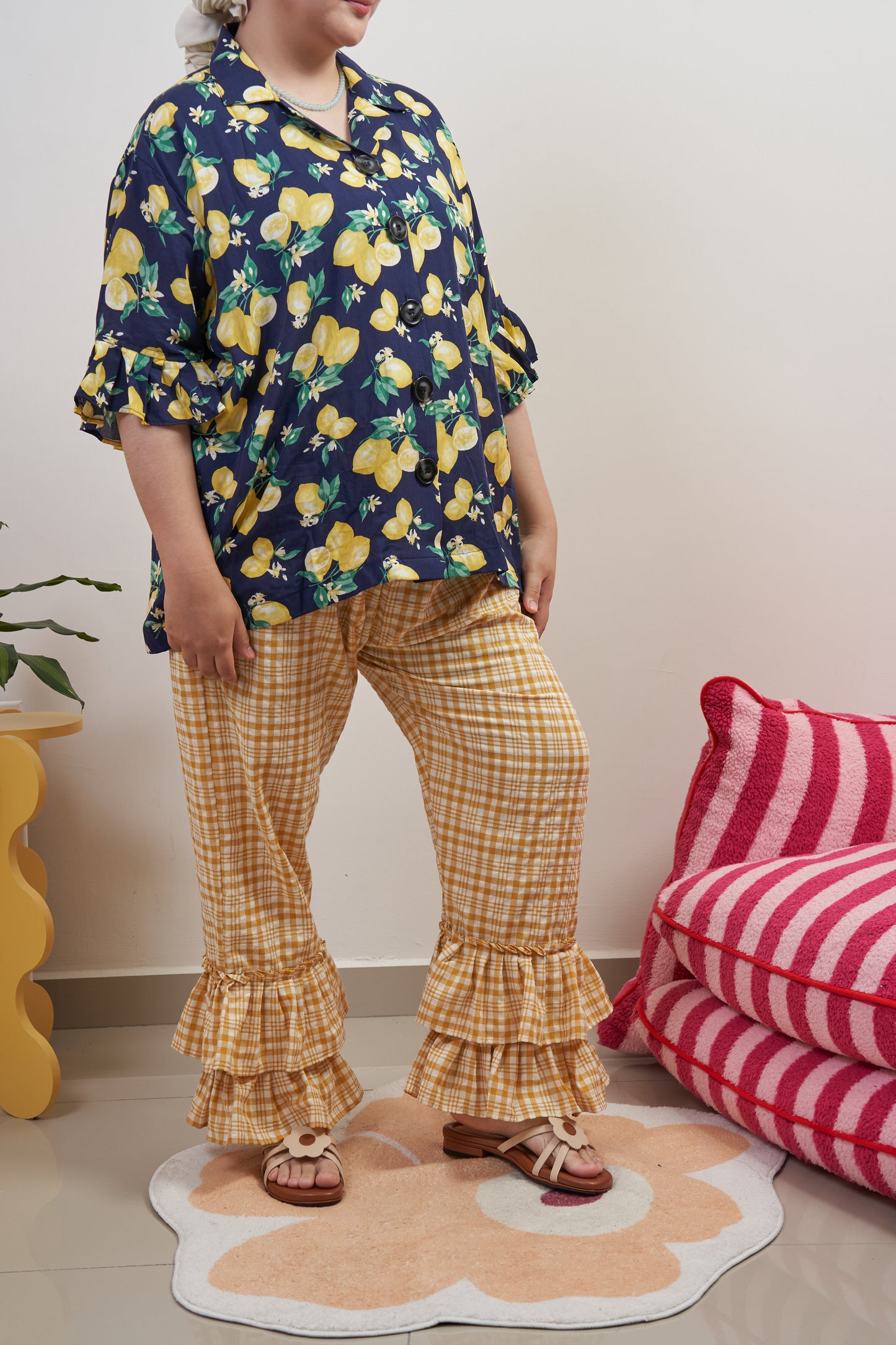 Semi side-front view of Flutter Flair Pants in Lemonade, one leg forward to highlight double ruffle hem and loose, modest fit.