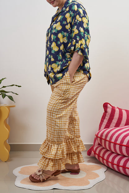 Side view of Flutter Flair Pants in Lemonade, highlighting side seam pocket and double ruffle hem with loose fit