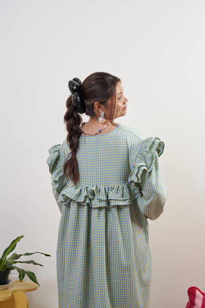 Half-body back view of Rhea Dress in Felicia Daisy, highlighting the ruffle details on the back, with yellow and blue gingham print